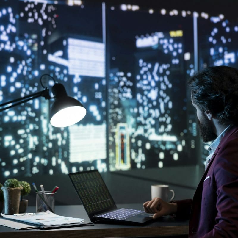 Private equity manager analyzing financial reports at night